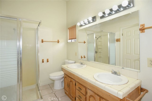 bathroom featuring toilet, tile patterned floors, an enclosed shower, and vanity