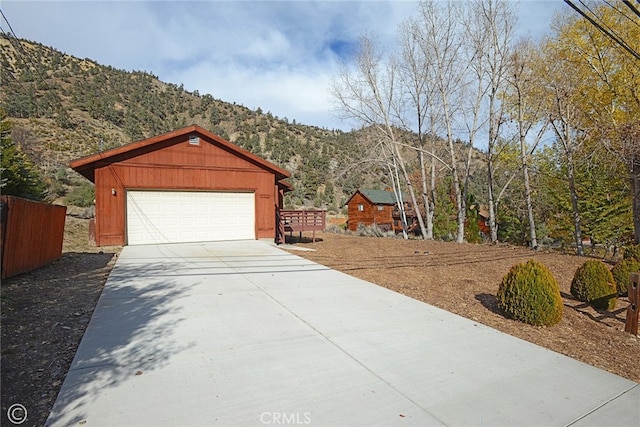 view of front facade with a garage, a mountain view, and an outdoor structure