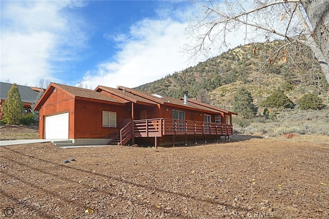 exterior space featuring a garage and a deck with mountain view