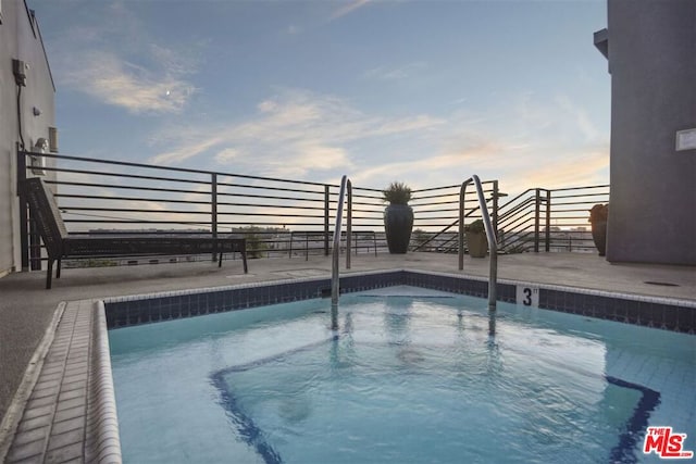 view of pool at dusk