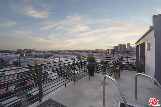 patio terrace at dusk featuring a balcony