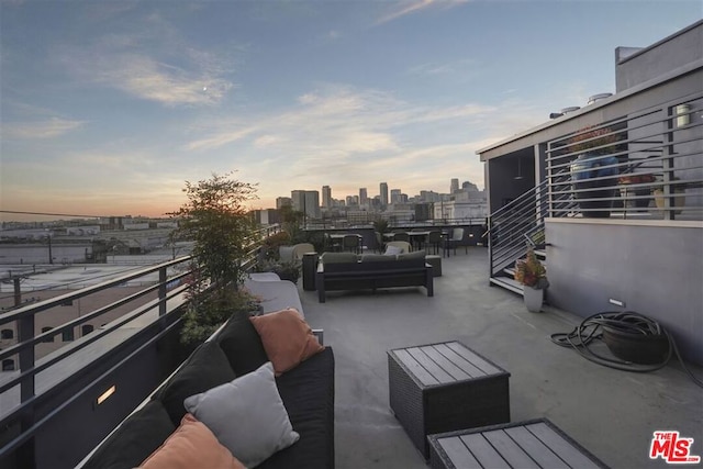 patio terrace at dusk featuring a balcony