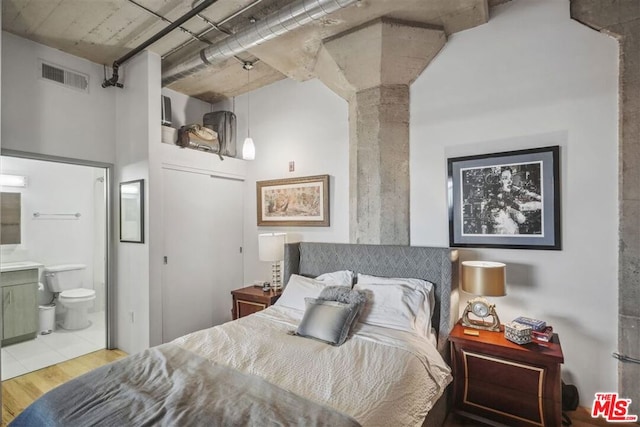 bedroom featuring light hardwood / wood-style floors and ensuite bath