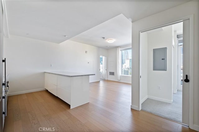 kitchen featuring electric panel, white cabinets, and light hardwood / wood-style floors