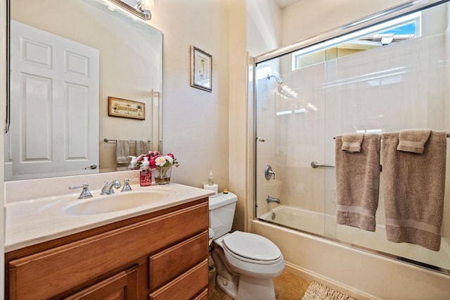 full bathroom featuring vanity, toilet, and bath / shower combo with glass door