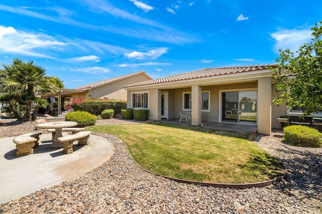 rear view of house featuring a patio area and a lawn