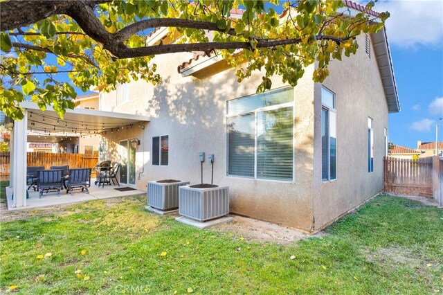 back of house featuring a yard, central AC, and a patio area