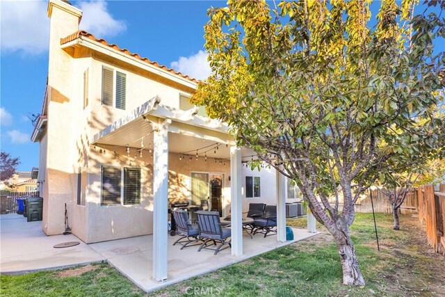 rear view of property featuring a patio area and a lawn