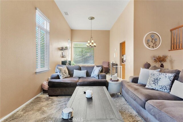 living room featuring a notable chandelier and carpet floors