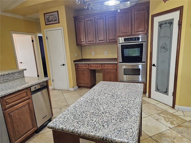 kitchen with a center island, light stone counters, and double oven