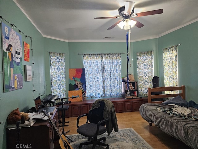 bedroom featuring ceiling fan, light wood-type flooring, and ornamental molding