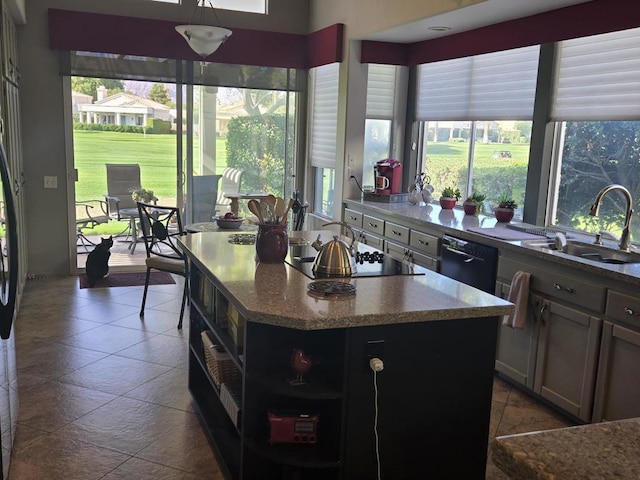 kitchen with sink, a center island, a healthy amount of sunlight, and black appliances