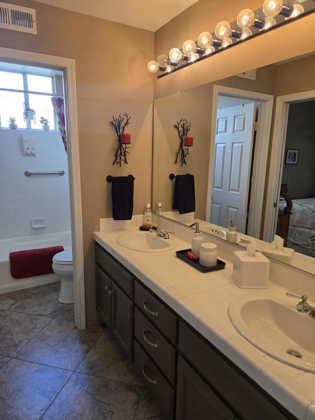 full bathroom featuring tile patterned floors, vanity, toilet, and tiled shower / bath