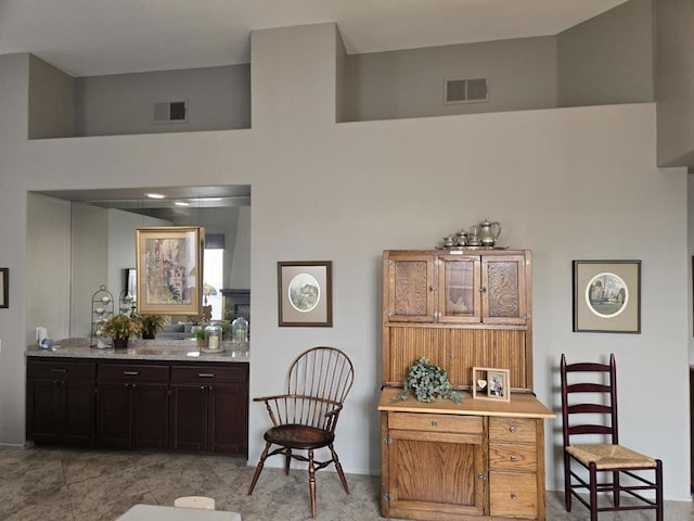 interior space with light tile patterned floors and a high ceiling