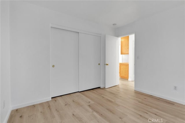 unfurnished bedroom featuring light hardwood / wood-style floors and a closet