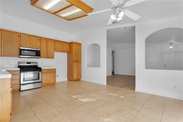 kitchen featuring ceiling fan, light tile patterned flooring, and stainless steel appliances