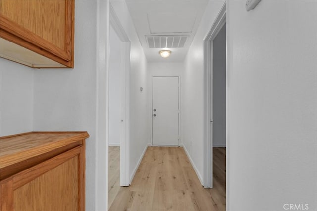 corridor with light hardwood / wood-style floors