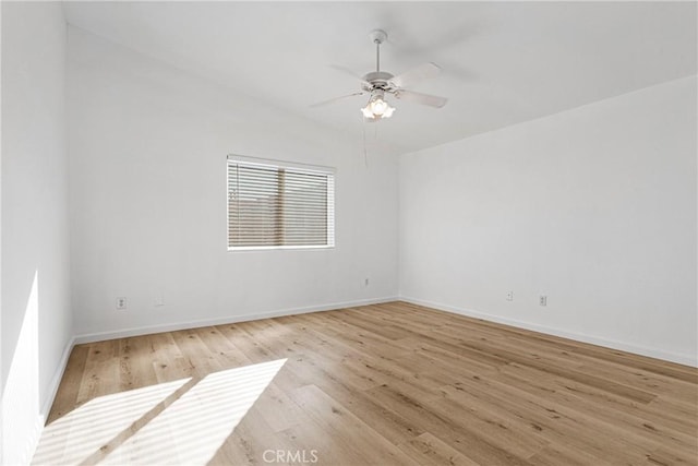 spare room with light hardwood / wood-style floors, vaulted ceiling, and ceiling fan