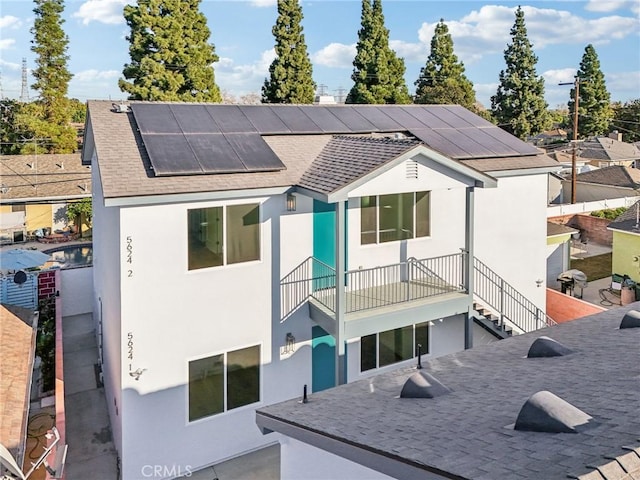 exterior space with a balcony and solar panels