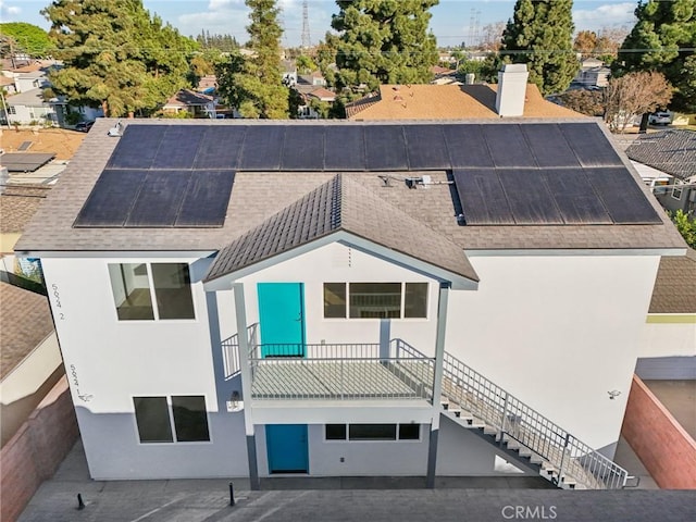 rear view of house featuring solar panels