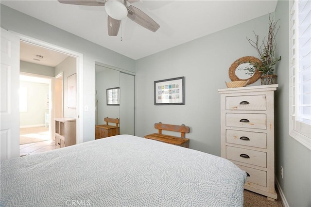 carpeted bedroom with ceiling fan and a closet