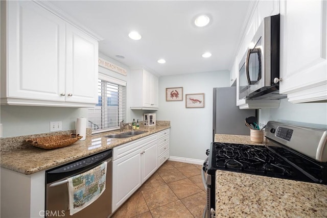 kitchen with light stone counters, white cabinetry, sink, and appliances with stainless steel finishes