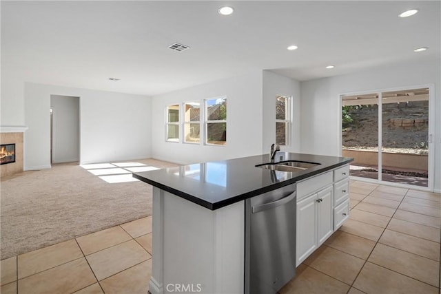 kitchen with light carpet, white cabinets, sink, stainless steel dishwasher, and a healthy amount of sunlight