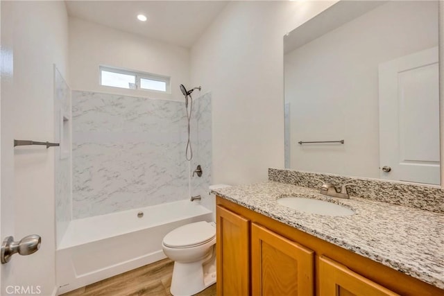 full bathroom with tiled shower / bath combo, toilet, wood-type flooring, and vanity