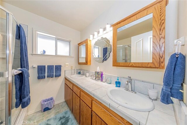 bathroom featuring tile patterned floors, vanity, and a shower with door