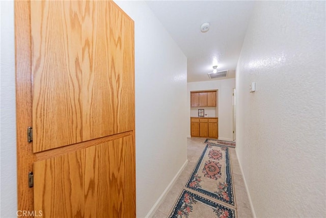 hall with light tile patterned floors