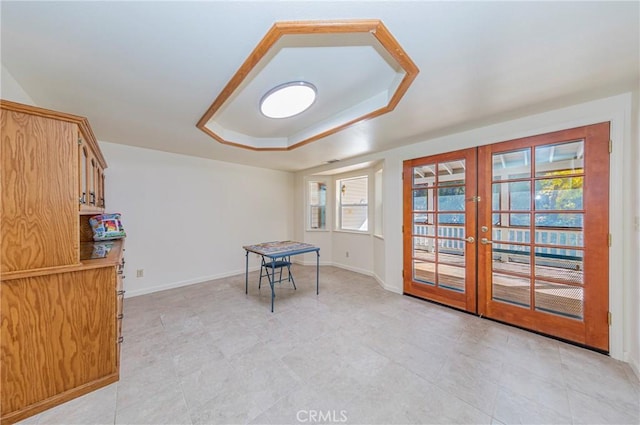 playroom featuring french doors and a raised ceiling