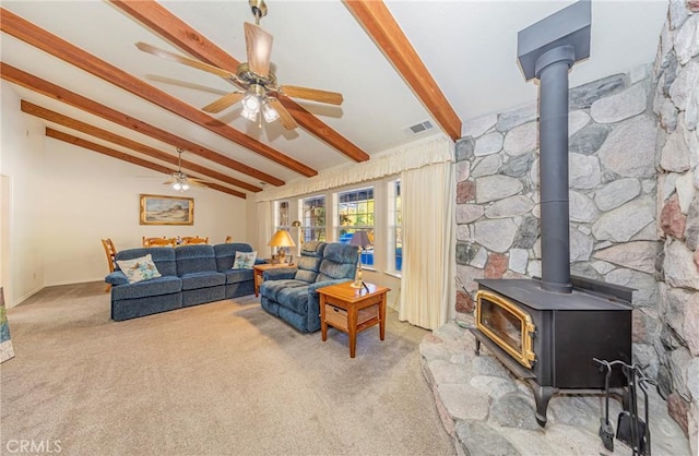 living room featuring carpet flooring, lofted ceiling with beams, and a wood stove