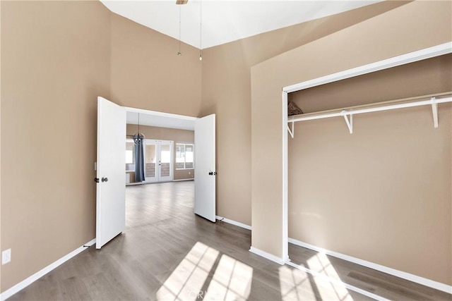 interior space with hardwood / wood-style flooring, a closet, and a high ceiling