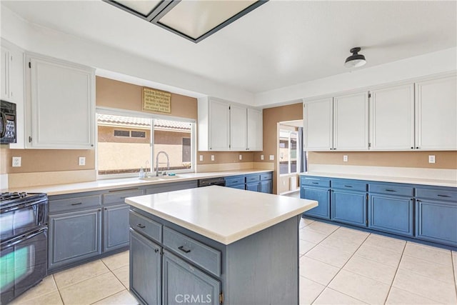 kitchen with sink, white cabinets, range with two ovens, a center island, and light tile patterned floors