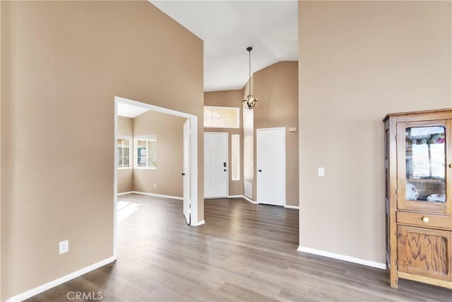 foyer entrance with hardwood / wood-style flooring and high vaulted ceiling