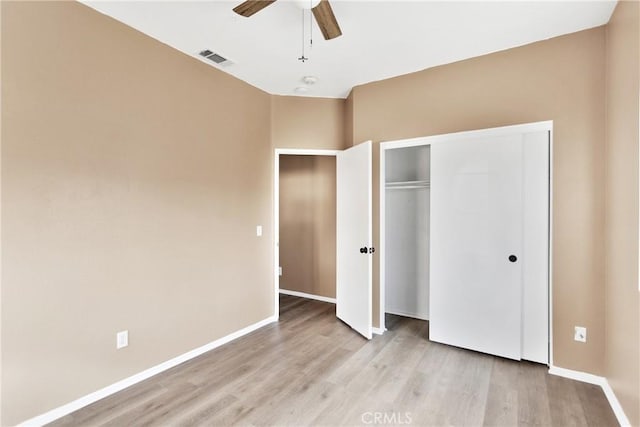 unfurnished bedroom featuring light hardwood / wood-style floors, a closet, and ceiling fan