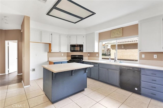 kitchen featuring a kitchen island, white cabinetry, sink, light tile patterned floors, and black appliances