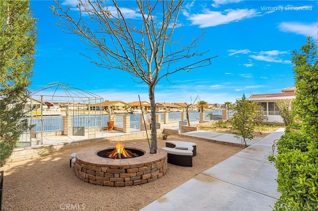 view of patio / terrace featuring a fire pit, a gazebo, and a water view