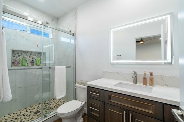 bathroom with vanity, toilet, and a shower with shower door