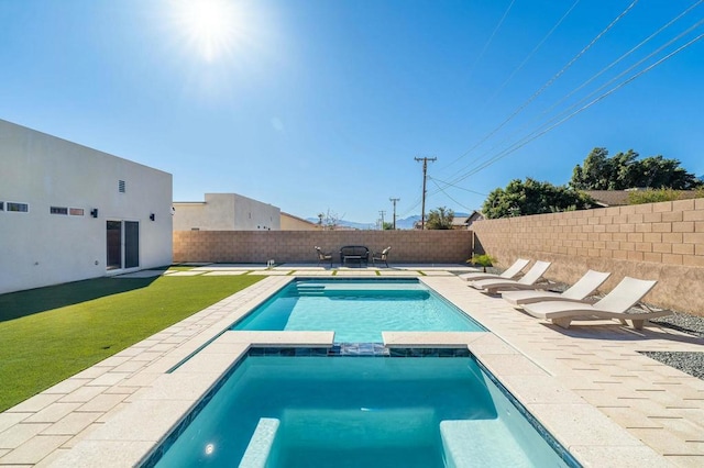 view of pool featuring an in ground hot tub and a yard