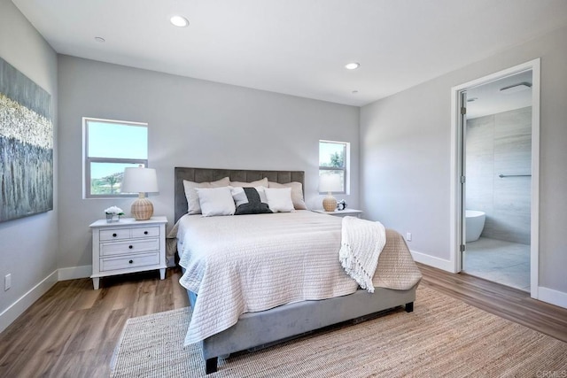 bedroom with hardwood / wood-style flooring and ensuite bath