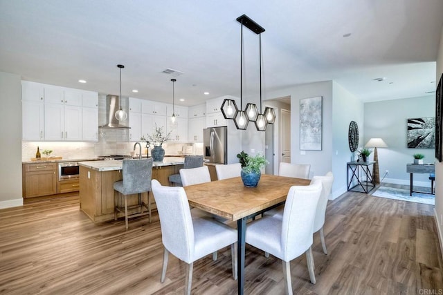 dining room with light hardwood / wood-style flooring and sink