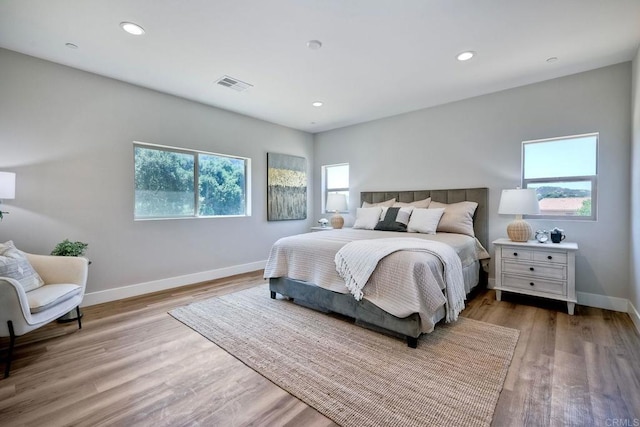 bedroom with light hardwood / wood-style flooring and multiple windows