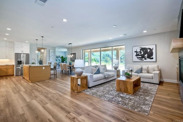 living room with light wood-type flooring and sink