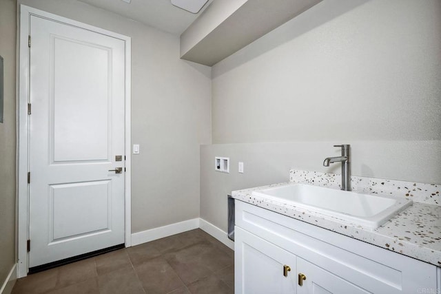 washroom featuring cabinets, hookup for a washing machine, dark tile patterned floors, and sink