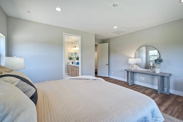 bedroom with dark hardwood / wood-style floors and connected bathroom