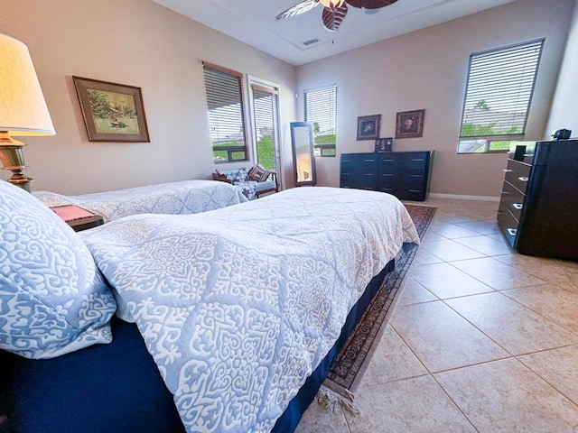 tiled bedroom featuring ceiling fan and multiple windows