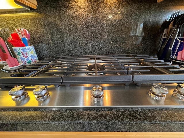 room details with stainless steel gas stovetop and backsplash