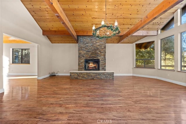 unfurnished living room with wood ceiling, a stone fireplace, hardwood / wood-style floors, and lofted ceiling with beams