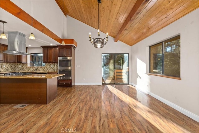 kitchen with light stone countertops, tasteful backsplash, stainless steel double oven, decorative light fixtures, and wooden ceiling